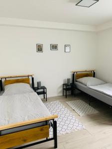 1 dormitorio con 2 camas y pared blanca en Apartments WK, en Colonia