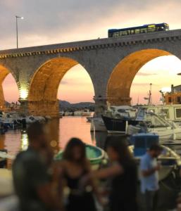 a train on a bridge over a harbor with boats at Les Cabanons de Fonfon in Marseille