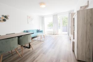 ein Wohnzimmer mit einem Tisch und einem blauen Sofa in der Unterkunft Modernes und zentrales 4 Zimmer Apartment in Hamburg