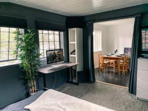 a bedroom with a bed and a desk with a computer at Solrik hytte med tilgang til brygge og stor hage in Risør