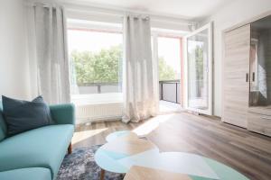 Modernes und zentrales 4 Zimmer Apartment في هامبورغ: غرفة معيشة مع أريكة زرقاء وطاولة
