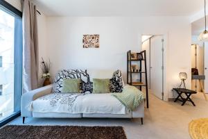 biała sypialnia z łóżkiem i oknem w obiekcie MalagaSuite Duplex con Parking w Maladze