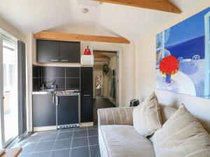 a living room with a couch and a kitchen at Ouzi's Place in Loughborough