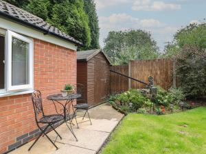 a patio with two chairs and a table in a yard at Ouzi's Place in Loughborough