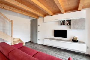 a living room with a red couch and a tv at Jack House in Domaso