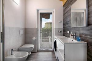 a bathroom with a sink and a toilet and a window at Jack House in Domaso +18 photos