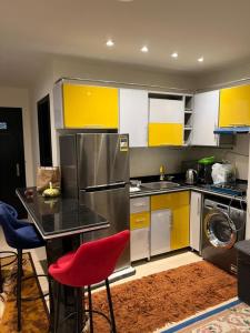 a kitchen with yellow and white cabinets and a red chair at porto marina north coast alamein in El Alamein