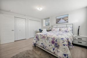 1 dormitorio con 1 cama con colcha de flores en Cozy Rockland Park Unit+Parking, en Calgary