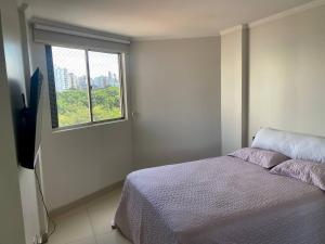 um quarto com uma cama e uma janela em Apartamento perfeito, bem localizado, confortável, espaçoso e com bom preço insta thiagojacomo em Goiânia