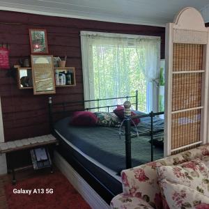 a bedroom with a bed and a window and a couch at Cottage / Mökki, unique summer cottage in Vihti