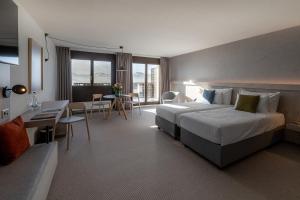 pokój hotelowy z łóżkiem, stołem i krzesłami w obiekcie Victoria Hotel & Residence w mieście Villars-sur-Ollon
