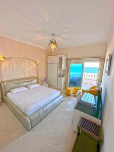 1 dormitorio con 1 cama grande y vistas al océano en Luxury Seafront Pool Villa - 3 Stories & Roof floor - All Master Bedrooms en Hurghada