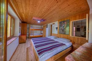 にあるCottage surrounded by forests - The Sunny Hillの木製の天井の客室のベッド1台分です。