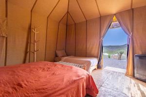 a room with two beds and a view of the desert at Agafay, La Ferme Nomade Bivouac in El Karia