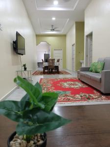a living room with a couch and a tv at SERI IBAI DAMAI in Kuala Terengganu