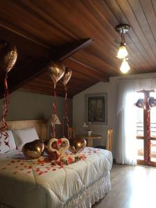Un dormitorio con una cama con dos cisnes. en Pousada Condado Brasileiro, en Campos do Jordão