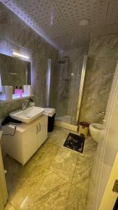 uma casa de banho com um lavatório, um chuveiro e um WC. em 2+1apartment em Esenyurt
