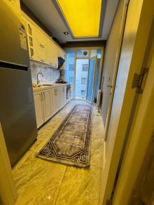 une cuisine avec un couloir et un tapis au sol dans l'établissement 2+1apartment, à Esenyurt