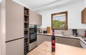 Una botella de vino sentada en una mesa en una cocina en 4 Bedroom Amazing Home In Kadumi, en Kadumi