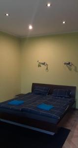 a bedroom with a bed with blue sheets and two birds on the wall at Recreation Center Brūveri in Sigulda