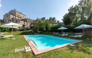a swimming pool in a yard with umbrellas at Vacanza Valentia in Vasciano Nuovo