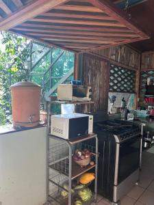 a kitchen with a stove and a microwave at Orgánico Punta Riel in Cahuita