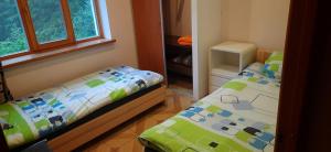 a small bedroom with two beds and a window at Recreation Center Brūveri in Sigulda