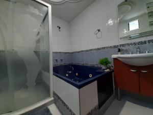 uma casa de banho com uma banheira azul e um lavatório. em Casa San Vicente em San Vicente de Chucurí