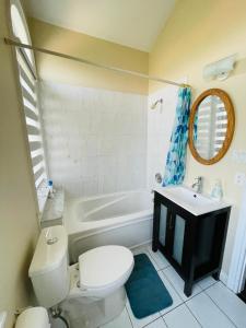 a bathroom with a toilet and a tub and a sink at Jazzy Home Stay in Mississauga