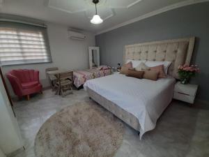 San Vicente de ChucuríにあるCasa San Vicenteのベッドルーム1室(大型ベッド1台、赤い椅子付)