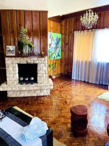 uma sala de estar com lareira e paredes de madeira em Melia's House Baguio - Nature Home for Rent em Baguio