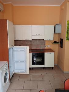 - une petite cuisine avec des placards blancs et un lave-vaisselle dans l'établissement Hostel Le Stanze del Sogno, à Bénévent