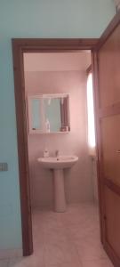 a bathroom with a sink and a mirror at La Perla nel Blu in Villasimius