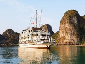 um barco sentado na água ao lado de algumas rochas em Victory Boutique Cruise em Ha Long