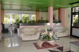 a lobby with two couches and a table with flowers at Hotel Il Parco in Grosseto
