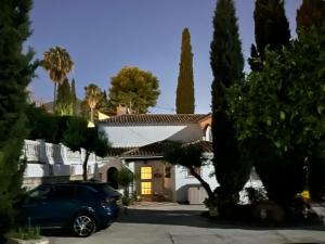 a car parked in front of a house with trees at Finca Villordo Villa Tranquila in Benalmádena