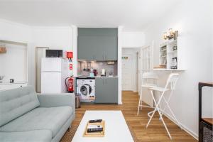 a living room with a couch and a kitchen at BeGuest Cascais Cozy Studio in Cascais