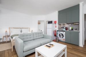 a living room with a couch and a kitchen at BeGuest Cascais Cozy Studio in Cascais