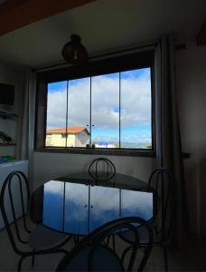 une table et des chaises dans une chambre avec une grande fenêtre dans l'établissement Pousada Pouso e Prosa, à Lavras Novas