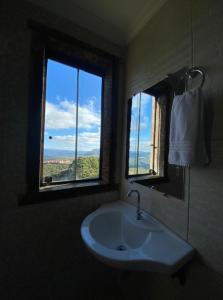 a bathroom with a sink and a window with a view at Pousada Pouso e Prosa in Lavras Novas