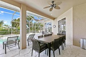 - une salle à manger avec une table, des chaises et une piscine dans l'établissement Mile From Beach Access, Spacious and Redone, Heated Pool!, à Marco Island