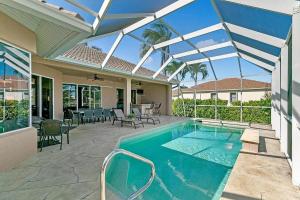 - une piscine dans une maison avec un toit dans l'établissement Mile From Beach Access, Spacious and Redone, Heated Pool!, à Marco Island