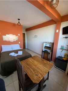 a bedroom with a bed and a wooden table at Pousada Pouso e Prosa in Lavras Novas
