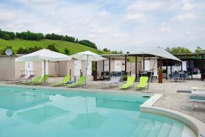 a swimming pool with lawn chairs and umbrellas at Dimora Il Feudo Apt 20 in Asti