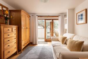 a living room with a couch and a dresser at East Trenean Farm Cottages -4 Luxury Cornish Cottages sleeping 20 with hot tubs, private gardens, rural views and EV facilities in Looe