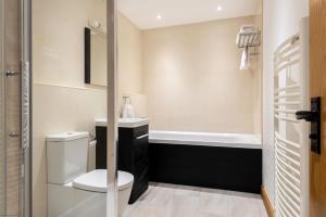 a bathroom with a toilet and a sink and a tub at East Trenean Farm Cottages -4 Luxury Cornish Cottages sleeping 20 with hot tubs, private gardens, rural views and EV facilities in Looe +36 photos