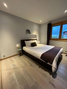 una camera con un grande letto e una grande finestra di Appartement La Suite du Kandahar à Chamonix a Chamonix-Mont-Blanc