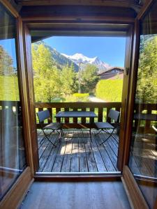 patio con tavolo e sedie su una terrazza di Appartement La Suite du Kandahar à Chamonix a Chamonix-Mont-Blanc
