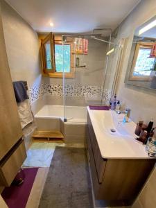 uma casa de banho com uma banheira, um lavatório e um chuveiro em Appartement La Suite du Kandahar à Chamonix em Chamonix-Mont-Blanc
