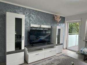 a living room with a tv and a white entertainment center at Traumhaftes Zuhause! in Forstinning
